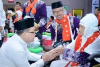 Pj Gubernur Jawa Timur Adhy Karyono menyalami salah satu jemaah saat pelepasan kloter pertama  jemaah haji dari asrama haji Sukolilo Surabaya ( Foto : Biro Adpim Pemprov Jatim )