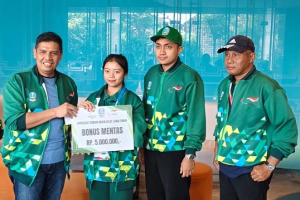 Kepala Dinas Pemuda dan Olahraga Pemerintah Provinsi Jawa Timur, Muhamad Hadi Wawan Guntoro (kiri), menyerahkan langsung bonus mentas kepada Ria Yulianti (dua dari kiri), atlet para taekwono peraih medali emas Pekan Paralimpiade Nasional XVII 2024 di Solo, Jawa Tengah, Minggu (13/10/2024). Pemprov Jatim merasa bangga dengan raihan medali para atlet para, karena mereka berhasil melampaui target perolehan medali yang ditetapkan. (Foto.Istimewa) 